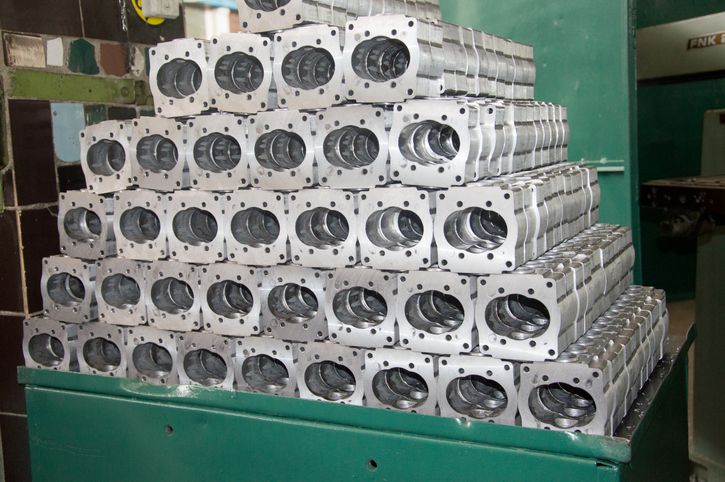 Pile of high precision metal parts demonstrating high volume sheet metal manufacturing USA.