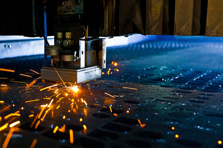 A close-up of a laser cutting high volume metal parts